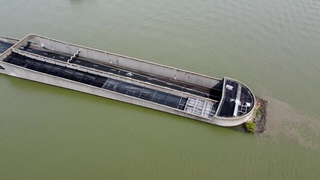 Aerial pan down view of highway tunnel going underwater traffic moving in both ways located in Holland which is well known for its innovative water management and infrastructure solutions 4k quality