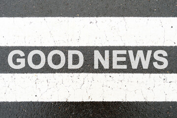 On the asphalt between the white dividing stripes the inscription - GOOD NEWS