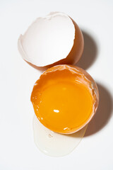 broken chicken egg on white background, vertical