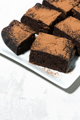 dessert - pieces of chocolate brownies on white table, vertical top view