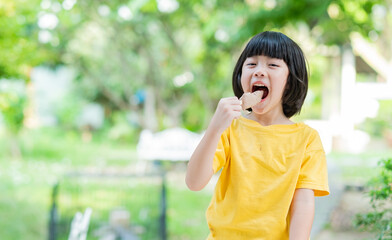 Fototapeta premium asian girl eating ice cream with blur background