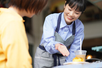 デザートを提供する女性店員