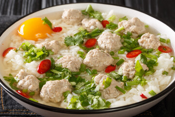 Easy Thai rice soup with meatballs Khao tom moo closeup in the plate on the table. Horizontal