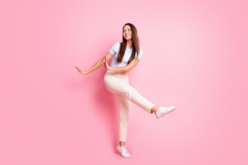 Full size photo of happy smiling lovely charming woman look copyspace dancing isolated on pink color background