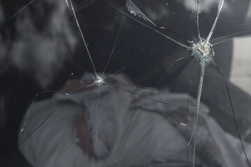 Cracks on old car windshield closeup, toned