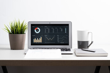 Laptop with  graph chart report screen on work table. Home office or work space. Strategy analysis financial accounting concept