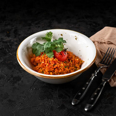 Basmati rice with turmeric and herbs. on plate on black slate background