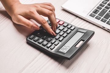 Closeup of using calculator on white textured background stock image.