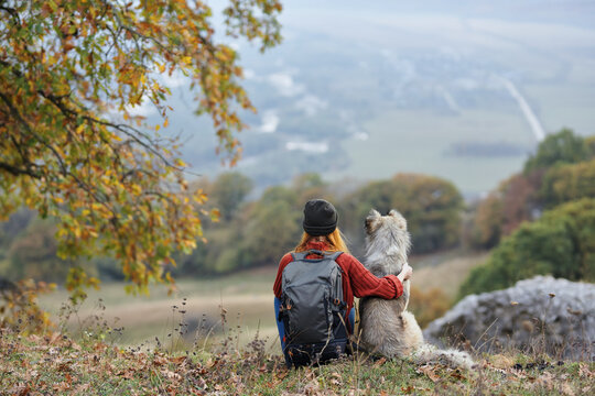 woman hiker next to dog admires nature mountains travel
