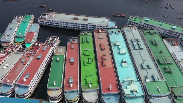 Aerial view of a busy wharf along Buriganga river with many sailing boats docked at shipyard in Keraniganj city, Dhaka state, Bangladesh.