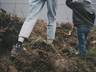 
mom and son are walking on the plot of their own house
