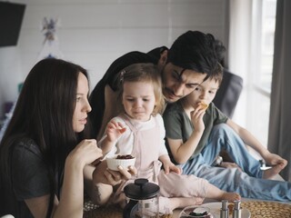 
family eats at home, children and parents, brother and sister