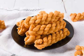 fried dough twist in plate on wooden table