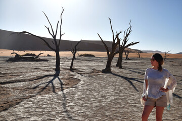 tourist woman visiting the dead vlei petrified trees in namibia
