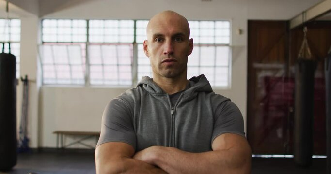 Portrait of fit caucasian man with arms crossed at the gym