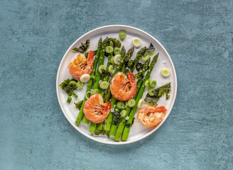 Seasonal salad from prawn shrimp, green asparagus, onion, and seaweed on a plate. Clean healthy eating.