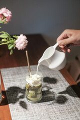 Coffee affogato with vanilla ice cream and espresso. Female hand pouring coffee in the glass with icecream	