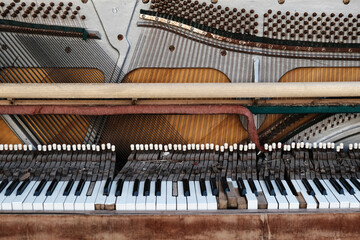 Old vintage piano with the lid off. A dilapidated musical instrument. Close-up. Selective focus.