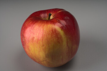 A yellow-red apple on a gray background.