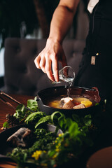 Russian traditional fish soup in a bowl - ukha, served with ember and vodka on wooden board. Fish broth. Traditional cuisine in Russia.