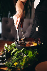 Russian traditional fish soup in a bowl - ukha, served with ember and vodka on wooden board. Fish broth. Traditional cuisine in Russia.