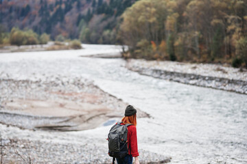 hiker with a backpack on the banks of the river in the mountains and landscape morning model tourism
