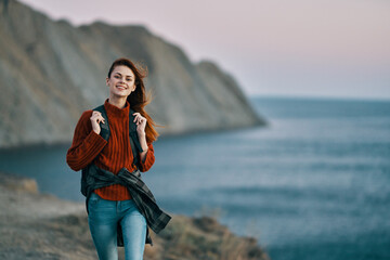 traveler with a backpack in the mountains in nature near the sea