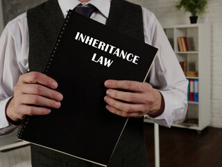 Jurist holds INHERITANCE LAW book. Inheritance law governs the rights of a decedent's survivors to inherit property.