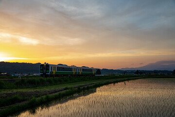 美しい夕日を浴びる只見線のローカル列車