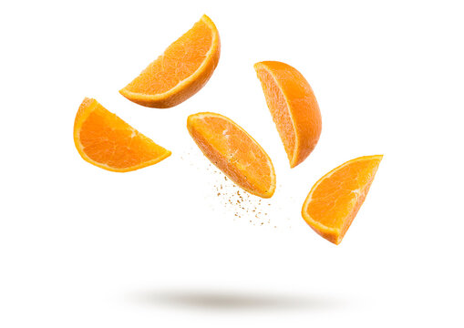 Orange fruit slices flying and dripping on white background