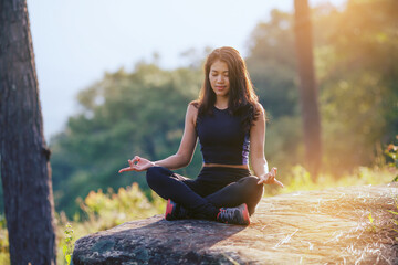front view asian woman doing yoga at the mountain

