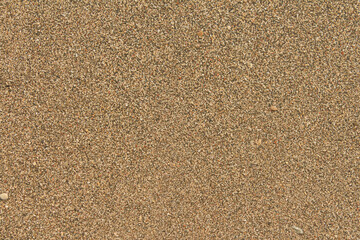 Sand pebble texture. Brown beach sand background.