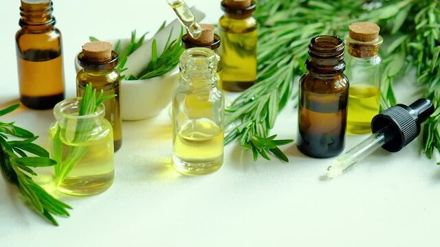 Rosemary essential oil in a small bottle. Selective focus.