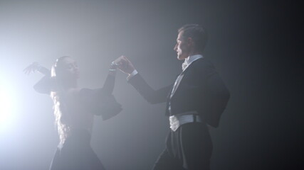 Professional dancers holding hands dancing. Ballroom couple performing waltz