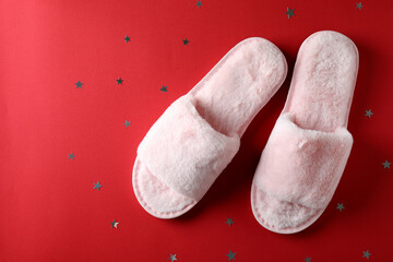 Pair of house slippers on red background