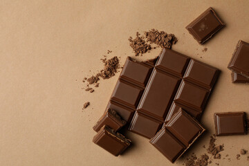 Tasty chocolate bar and powder on beige background