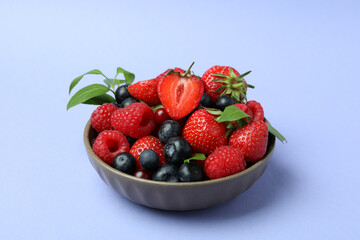 Bowl with berry mix on violet background