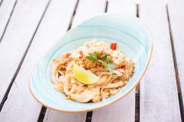 Delicious Shrimp Pad Thai with Vegetables on plate - Pad Thai sobre fondo palet blanco - Close Up