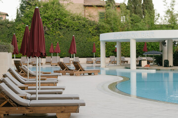 Empty hotel with umbrellas near pool, nobody because of virus, tourism crisis