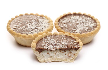 Mini chocolate tarts with coconut filling and shavings isolated on white background