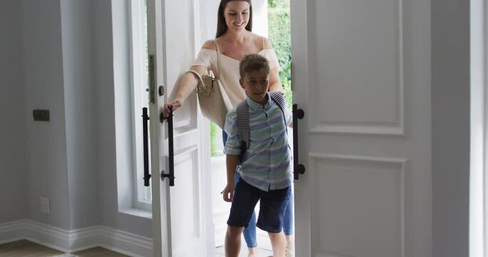 Excited Caucasian Son Running Through Front Door, Returning Home With Smiling Mother