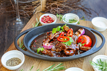 Roast meat with baked tomatoes and onions with sweet sauce, beautifully served in cast-iron dishes. Restaurant menu