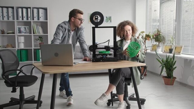 modern home improvement, creative man and woman use modern technologies and create prototypic 3D models on 3D printer at home