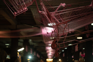 Painted shopping cart hanging from ceiling during indoor art exhibition 