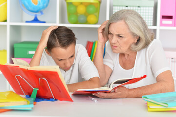 Fototapeta premium Grandmother with her grandson doing homework at home