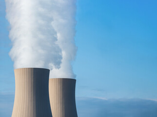 Nuclear power plant against sky at sunset