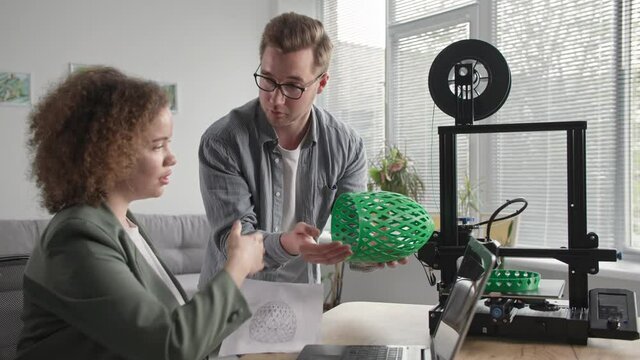 using 3d printer at home, talented female and male engineers print 3j prototype model using modern technologies at home
