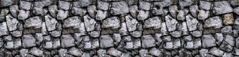 masonry wall texture. Black stones and rocks of different shape, gray background