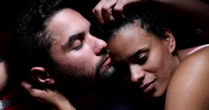 Hispanic couple in bed cuddling together