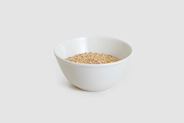White ceramic bowl with natural oat seeds